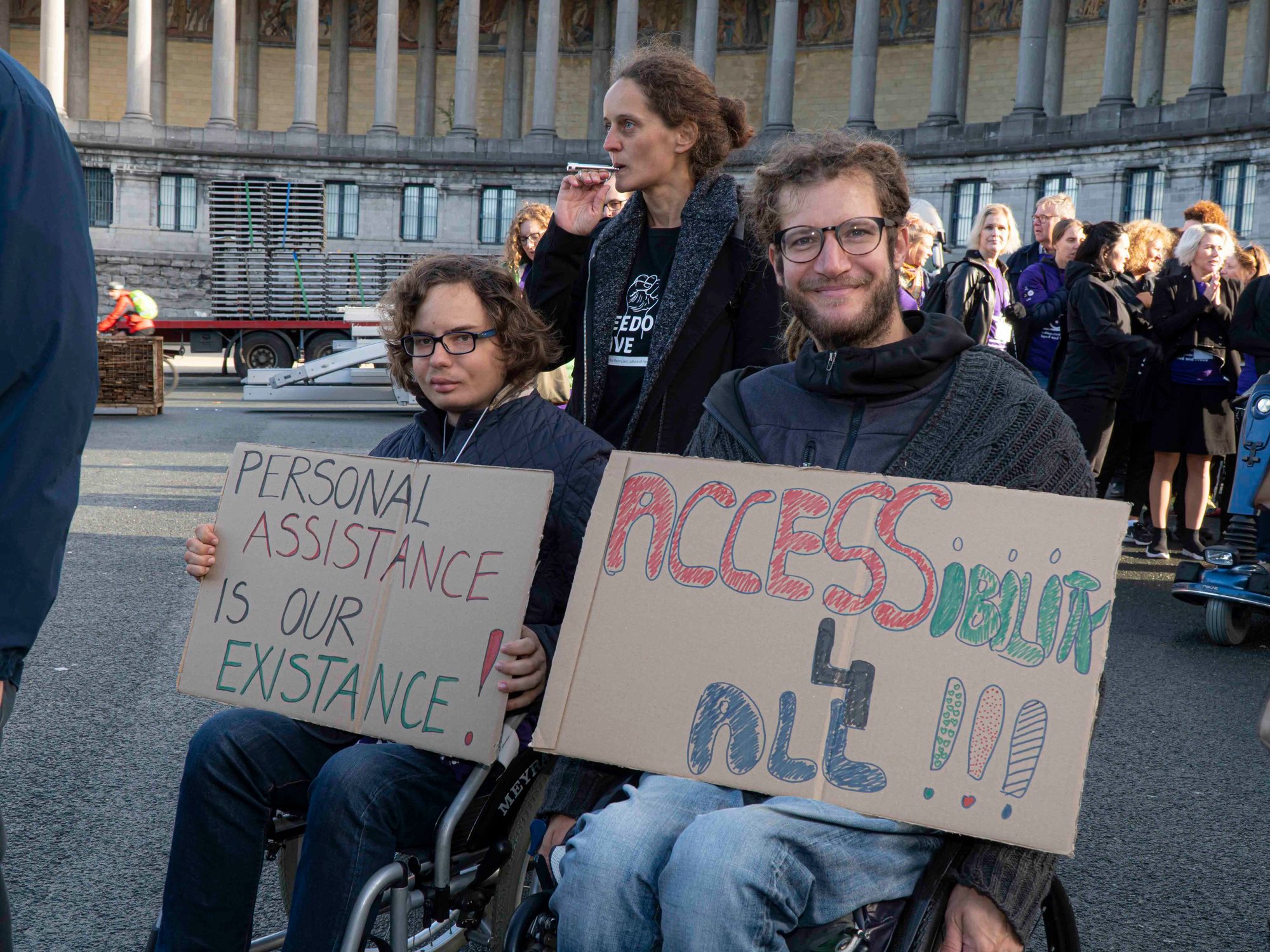 Two wheelchair users holding banners