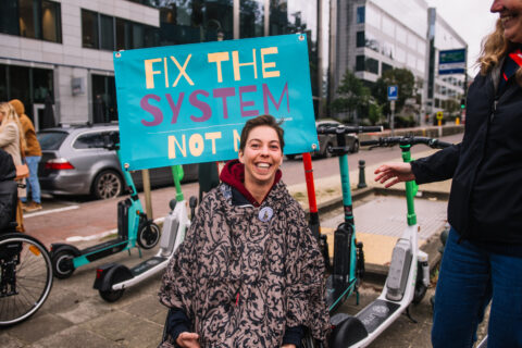 Protester with poster that says "fix the system, not me"