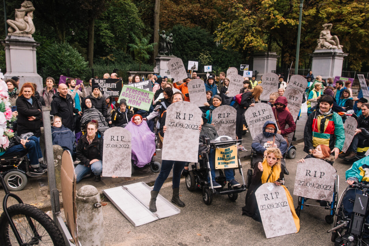 A group of people holding cardboard tombstones with the writing RIP 27.09.2022