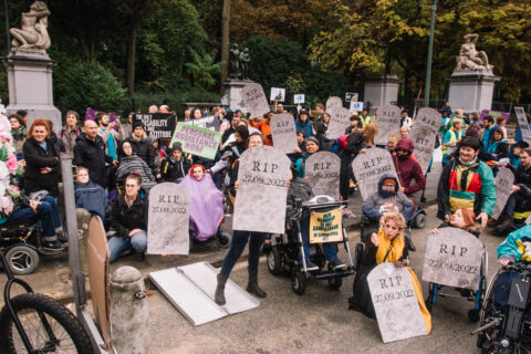 A group of people holding cardboard tombstones with the writing RIP 27.09.2022