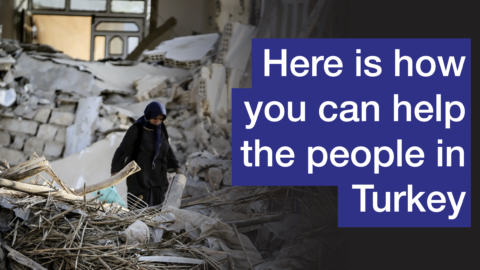Here is how you can help the people in Turkey. Image of a woman walking through the debris caused by the earthquake
