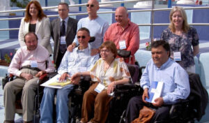 Two rows of people, all smiling at the camera, with wheelchair users in front