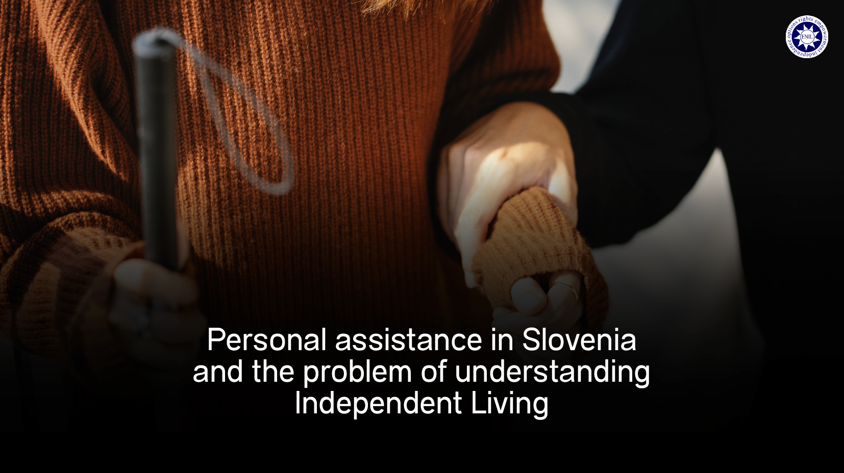 Photo of an assistant helping a blind person and the text says "Personal assistance in Slovenia and the problem of understanding Independent Living"