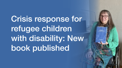 Woman in wheelchair smiling at the camera and holding a book in her hands. Text says "Crisis response for refugee children with disability: New book published"