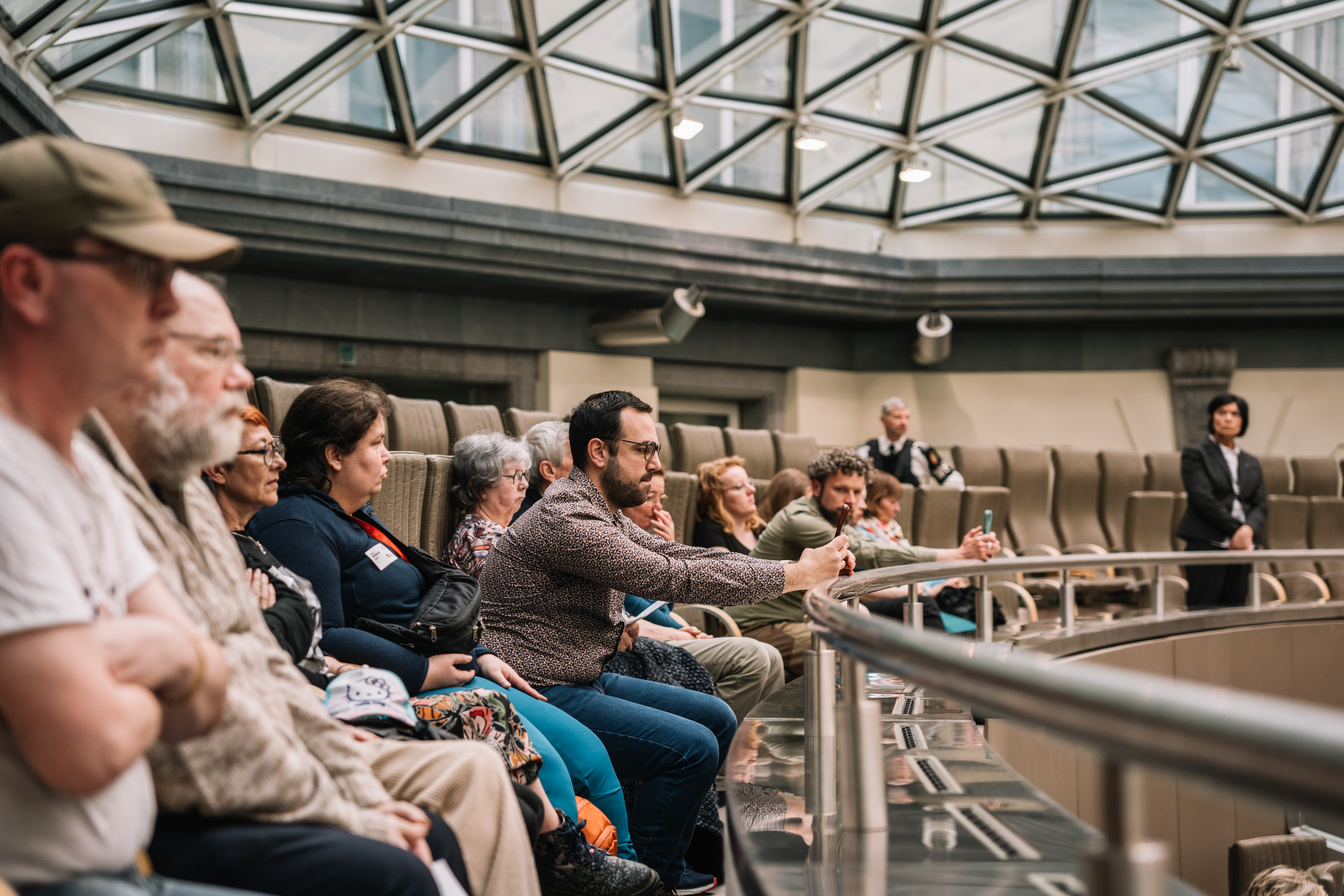 People attending a session of the parliament, listening to the discussion on disability rights