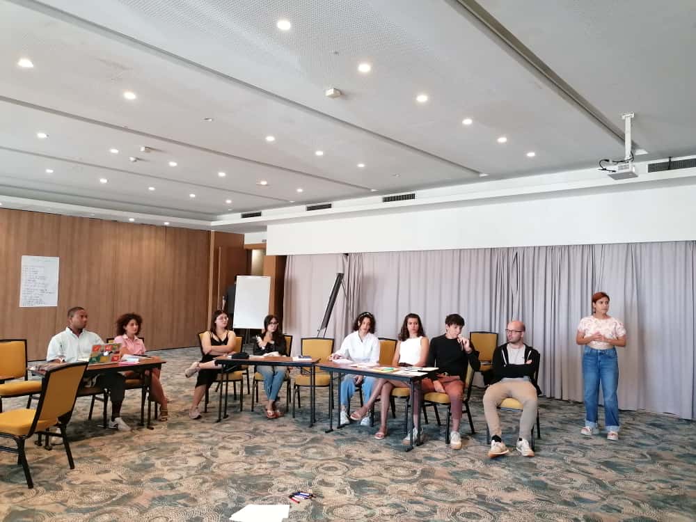 Group of people sat in a room, listening to someone