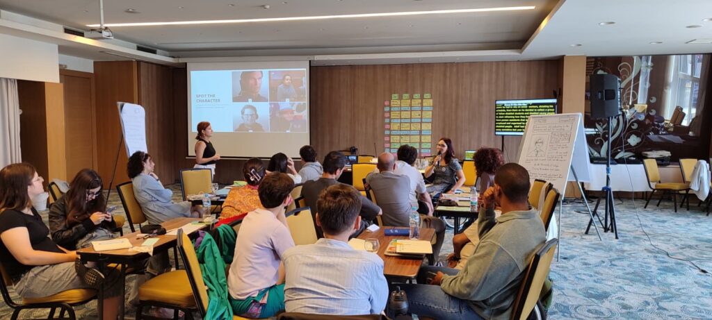 Group of people sat in a room, listening to someone