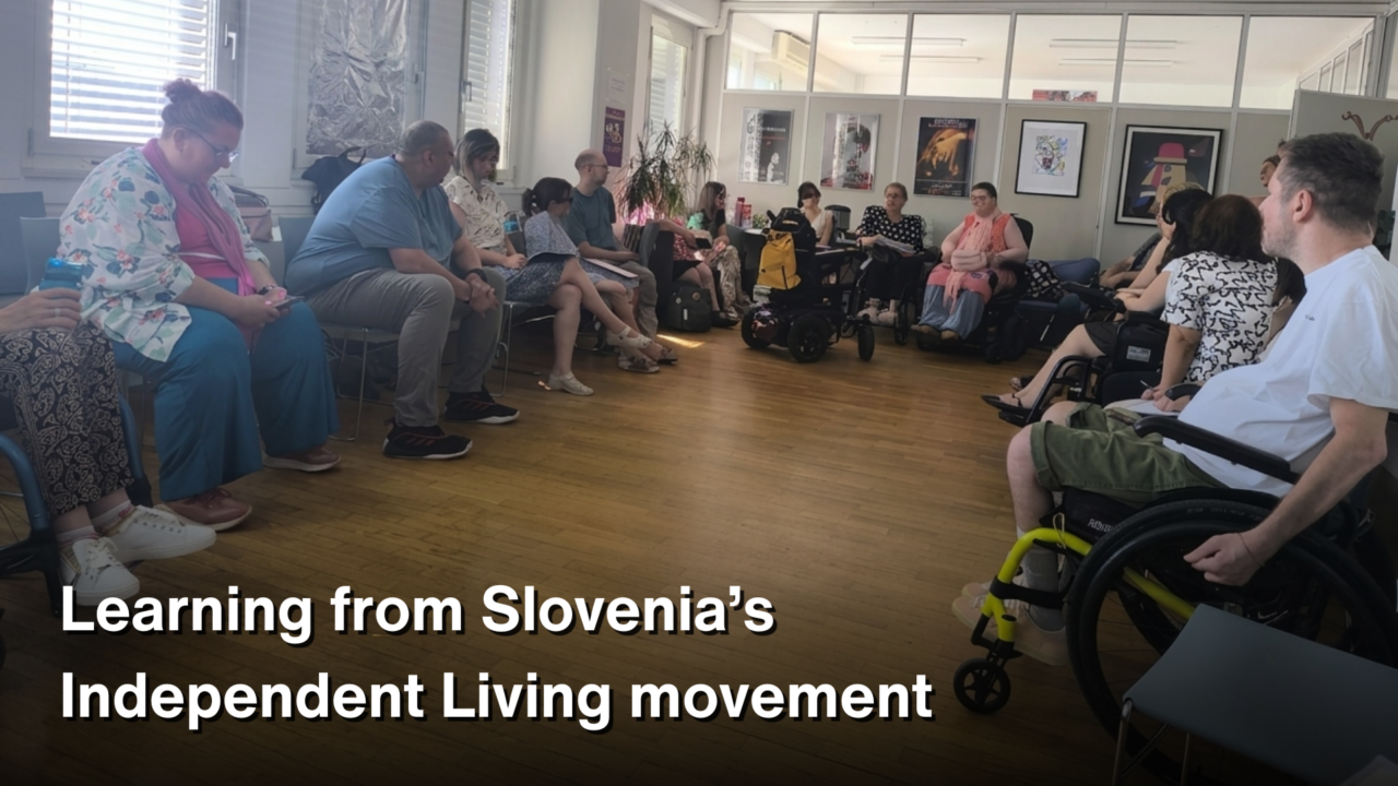 A group of people, including several wheelchair users, sit in a circle during a study visit discussion in Slovenia. White text over the lower part of the image reads: “Learning from Slovenia’s Independent Living movement.”