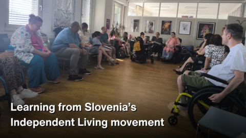 A group of people, including several wheelchair users, sit in a circle during a study visit discussion in Slovenia. White text over the lower part of the image reads: “Learning from Slovenia’s Independent Living movement.”